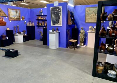 Gallery space with blue walls and antique sculptures